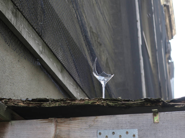 verre à vin tranchant cassé debout sur un vieux toit en bois
 - Photo, image