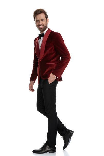 赤いベルベットのタキシードを着た幸せな若いファッションの男 - 写真・画像