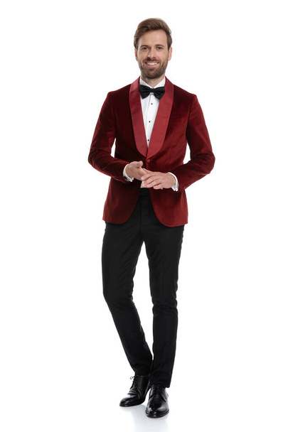 happy young man wearing red velvet tuxedo and black bowtie - Foto, afbeelding