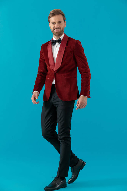 happy elegant man wearing red velvet tuxedo and walking - Fotografie, Obrázek