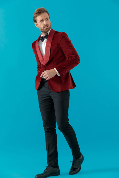κομψό άνθρωπος της μόδας φορώντας κόκκινο βελούδινο σμόκιν και το περπάτημα - Φωτογραφία, εικόνα