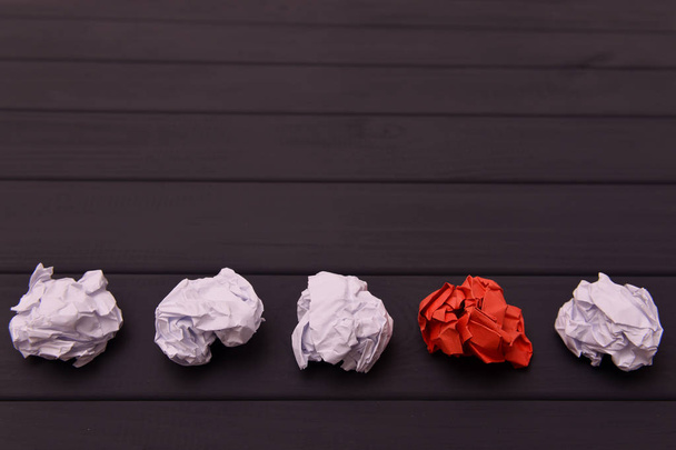 Crumpled white and red paper on a black wooden background. - Photo, Image