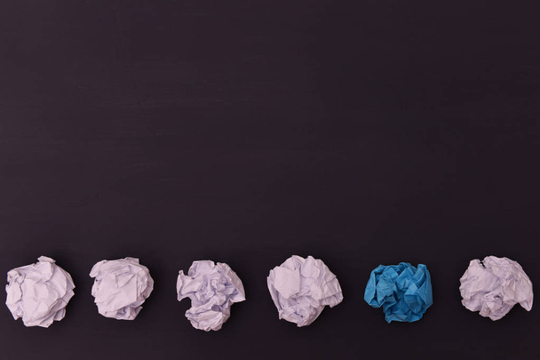 Crumpled white and blue paper on a black background. - Photo, image