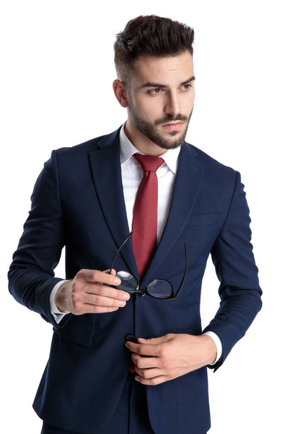 Knappe jonge zakenman met zijn bril en het aanpassen van zijn - Foto, afbeelding