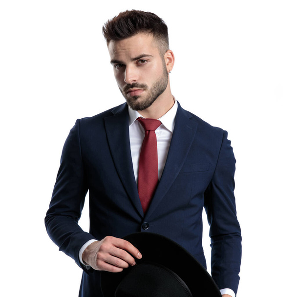 Handsome young businessman holding his black hat - Foto, immagini