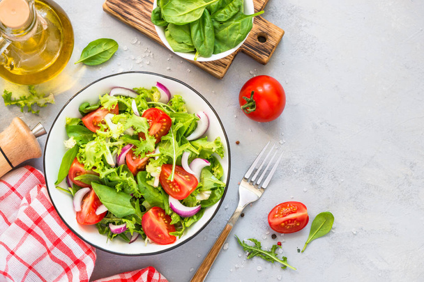 Green salad from fresh leaves and tomatoes. - Fotoğraf, Görsel