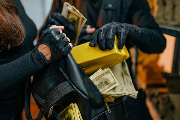 Robo de banco del siglo, dos ladrones en uniforme negro hackeado la bóveda. Profesión criminal, concepto de robo
 - Foto, imagen