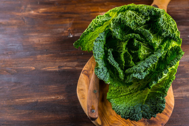 Fresh raw savoy cabbage on wooden background - 写真・画像