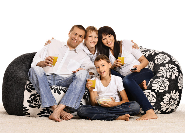 Family watching tv sitting on cushions - Foto, Bild
