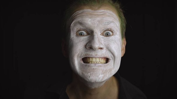 Cadılar Bayramı palyaço portresi. Şeytani bir palyaçonun yüzüne yakın çekim. Beyaz yüz makyajı - Fotoğraf, Görsel