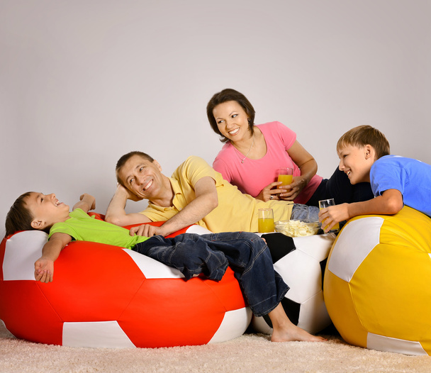Family watching tv, drinking and eating - Fotó, kép