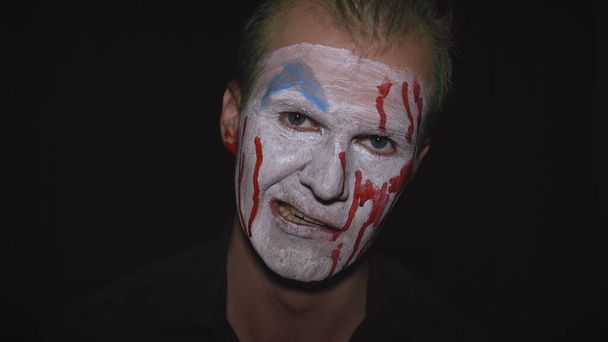 Portret klauna Halloween. Przerażająca, zła twarz klaunów. Biały makijaż twarzy - Zdjęcie, obraz