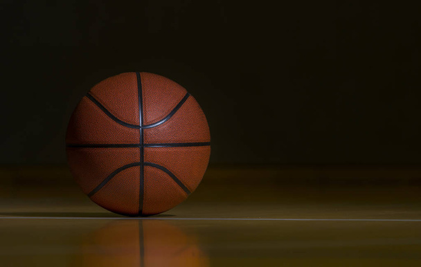 Basketball sur le plancher de cour de bois franc avec l'éclairage de tache
 - Photo, image