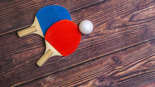 Dos raquetas para jugar al tenis de mesa sobre fondo de madera
 - Foto, imagen