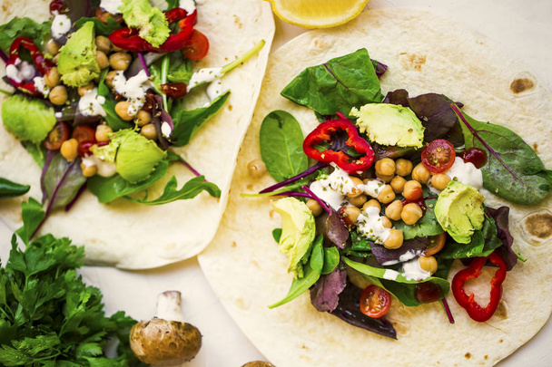Veganistische wraps met salade, avocado, peper, tomaten, kikkererwten en - Foto, afbeelding