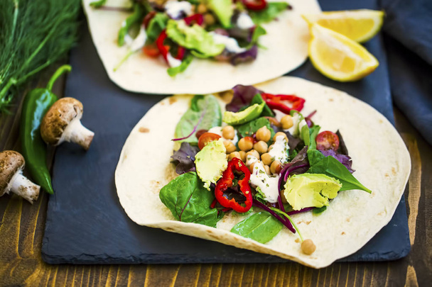 Veganistische wraps met salade, avocado, peper, tomaten, kikkererwten en - Foto, afbeelding