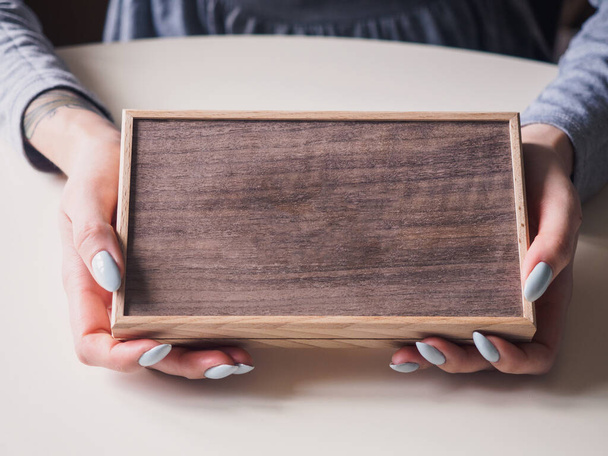 Caixa marrom retro de madeira em mãos femininas
 - Foto, Imagem