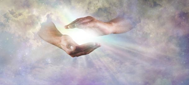 Laat er Licht Goddelijk Concept zijn - Gods handen die tevoorschijn komen uit prachtige wolken, samengeklemd, met regenboog gekleurde heldere witte ster lichtuitbarsting tussen en kopieer ruimte - Foto, afbeelding