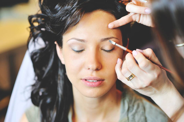 Joven novia hermosa aplicación de maquillaje de boda por el artista de maquillaje
 - Foto, Imagen