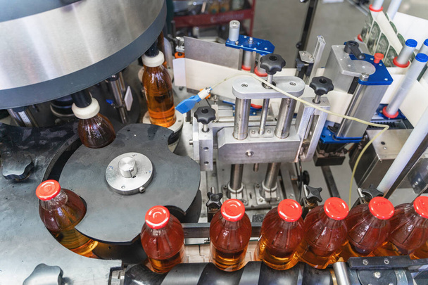 Correia transportadora, suco em garrafas de vidro em equipamento de máquina automatizado na fábrica de bebidas
 - Foto, Imagem
