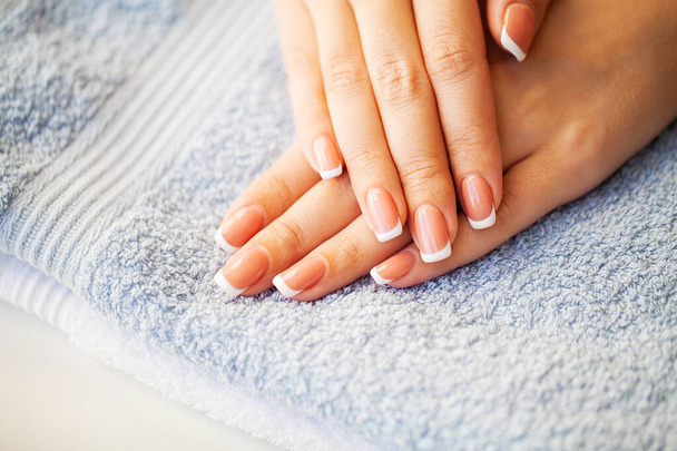 Nails care. Beautiful womans nails with french manicure, in beauty studio - Photo, Image