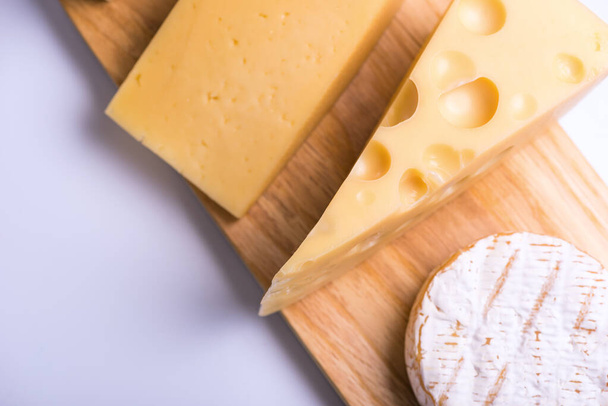 Deliziosi pezzi di formaggio diverso su un tavolo bianco
 - Foto, immagini