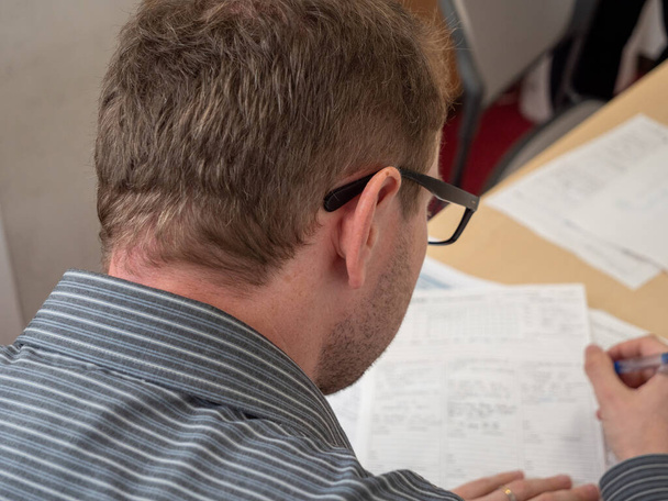A man writing up paperwork at work. - Photo, Image