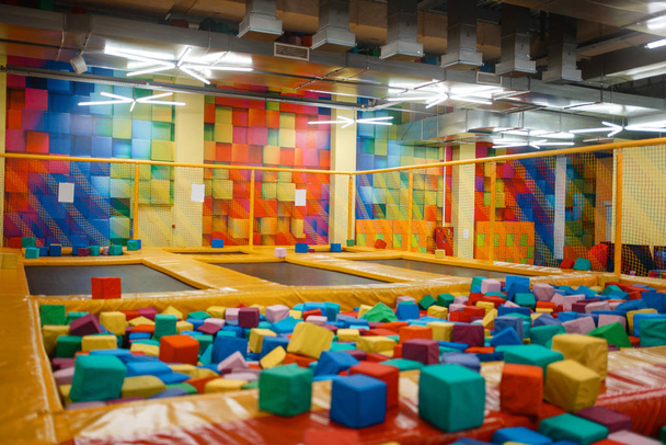 Kids trampoline and soft cubes on playground in entertainment center, nobody. Play area for children indoors, playroom - Photo, Image