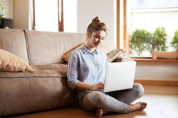 Happy woman with laptop on living room floor - Fotografie, Obrázek
