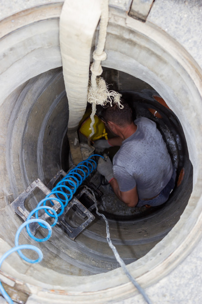 Worker inside a manhole - working in a manhole - Photo, Image