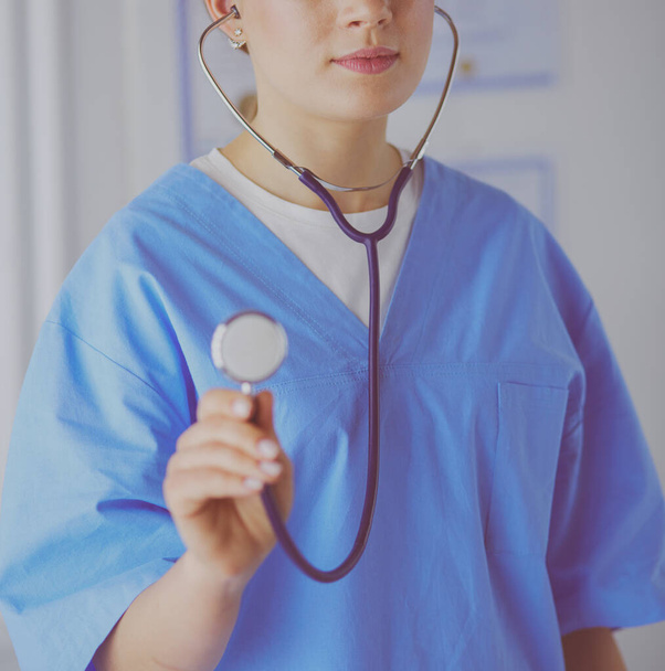 Nainen lääkäri seisoo stetoskooppi sairaalassa - Valokuva, kuva