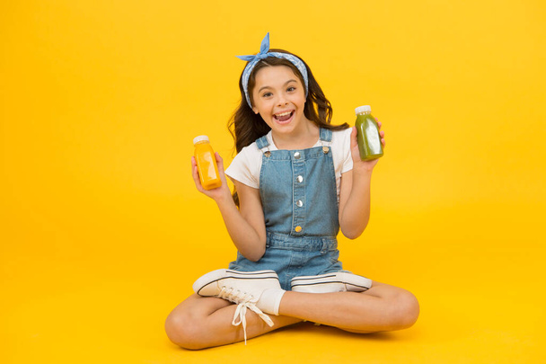 Lead a healthy life through nutritious eating and physical activity. Happy small girl hold bottles with healthy nutrition. Little child enjoy healthy lifestyle. Healthy diet for kids - Фото, зображення