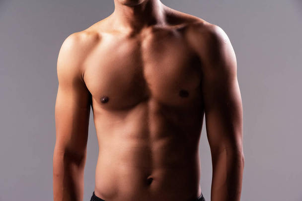 Гибкая мышца человека, демонстрирующая стройность и твердость тела после физических упражнений - Фото, изображение