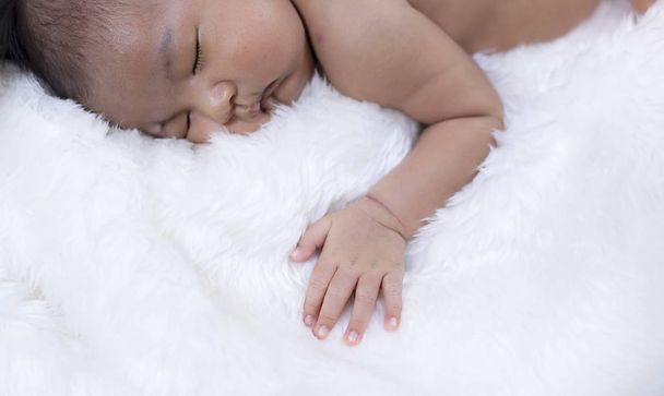 O bebê recém-nascido dormindo, colocar pouca mão esquerda sobre pano macio de algodão branco, luz borrada ao redor - Foto, Imagem