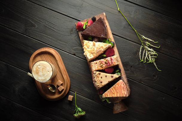 Διαφορετικά κομμάτια κέικ σε μια ξύλινη σανίδα. μενού τροφοδοσίας - Φωτογραφία, εικόνα