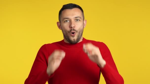 happy and surprised young man on yellow background - Záběry, video