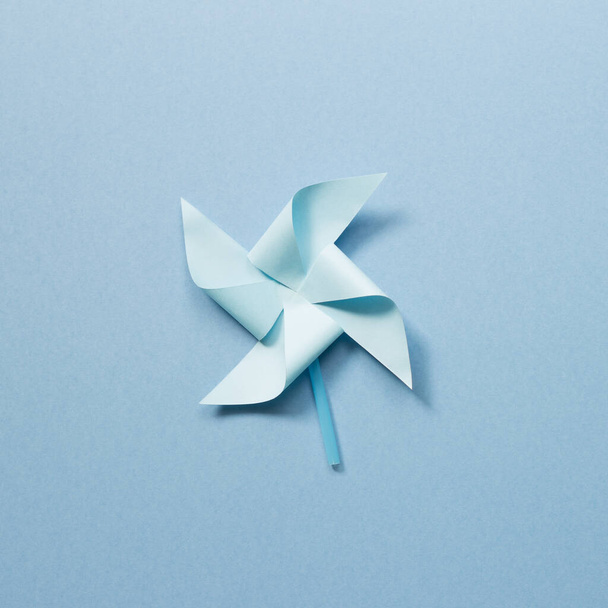 Blue paper pinwheel on blue background - Фото, зображення