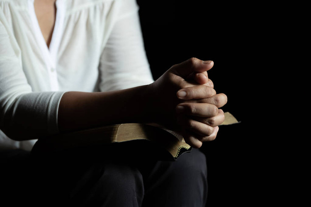 Espiritualidade e religião, Mãos dobradas em oração em uma Bíblia Sagrada
 - Foto, Imagem