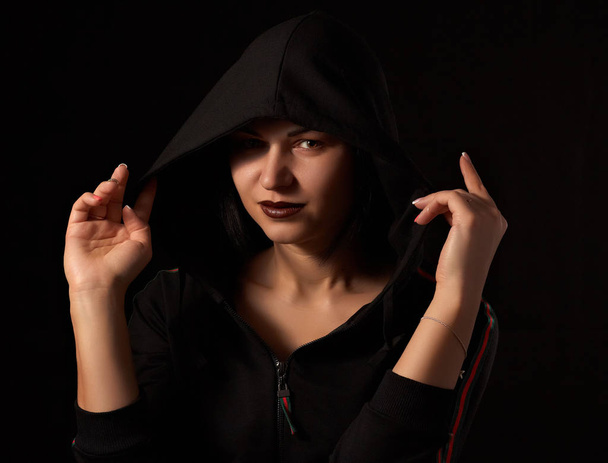 Monochrome image of a hooded woman on a dark background. - Photo, Image