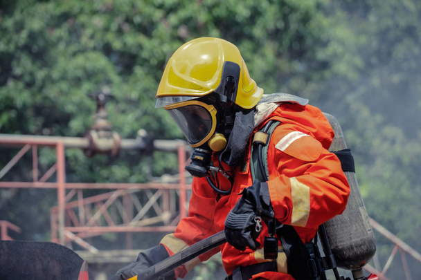 Πυροσβέστης φορώντας σουίτα ασφαλείας και περπατώντας στην περιοχή της πυρκαγιάς - Φωτογραφία, εικόνα