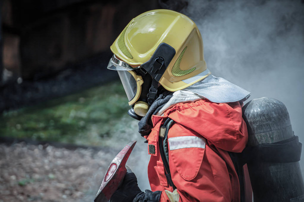 Feuerwehrmann im Schutzanzug und zu Fuß zum Brandschauplatz  - Foto, Bild
