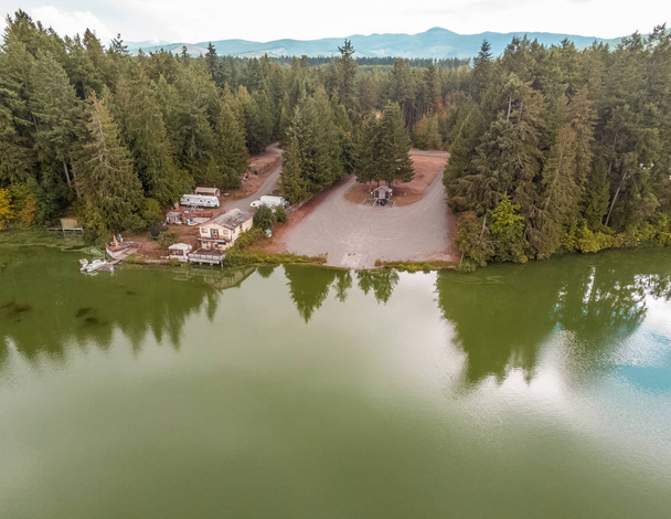 Superbe photographie aérienne du lac Clear du comté de Thurston avec les arbres et les nuages et les montagnes environnantes qui se reflètent dans les eaux en été. Situé à Yelm, Washington
. - Photo, image