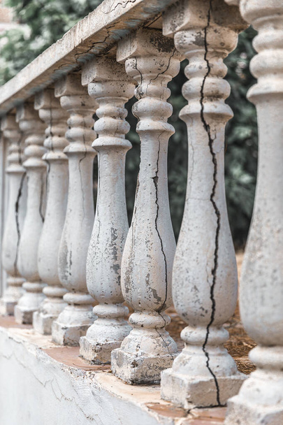 Старі колонки паркану на фоні саду. Повторювані стовпчики у перспективі
 - Фото, зображення