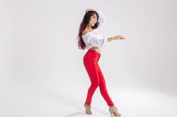 Latina dans, strip dans, hedendaagse en bachata dame concept - Vrouw dansen improvisatie en bewegen van haar lange haar op een witte achtergrond - Foto, afbeelding