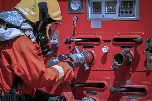 Feuerwehrmann im Schutzanzug nutzt das Hochdruckwate - Foto, Bild