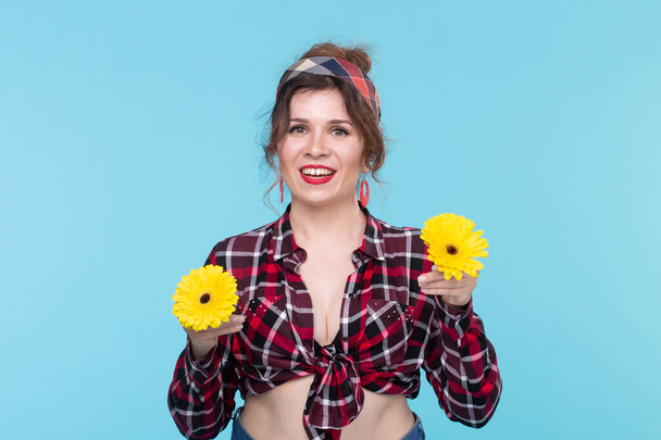 Summer, pin-up and fun concept - pretty woman with gerberas over the blue background - Photo, Image