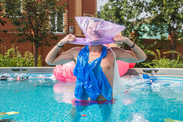 Ecología, basura plástica, emergencia ambiental y contaminación del agua - El hombre gritando con una bolsa de plástico sobre su cabeza en una piscina sucia
 - Foto, imagen