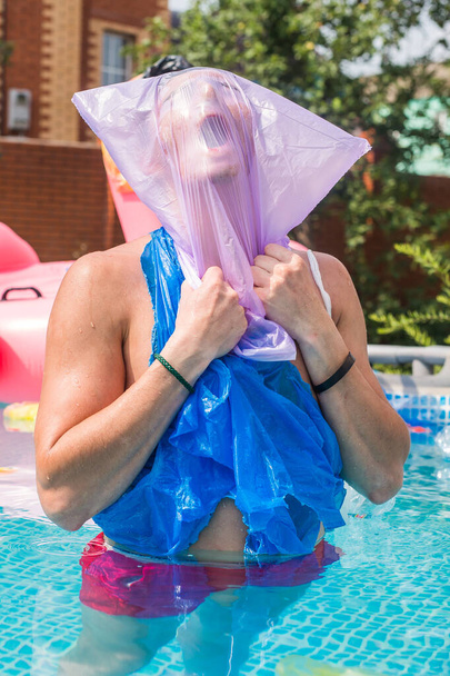 Ökologie, Plastikmüll, Umweltnotstand und Wasserverschmutzung - schreiender Mann mit Plastiktüte über dem Kopf in einem schmutzigen Schwimmbad - Foto, Bild