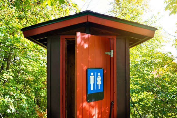 wunderschöne rote und braune öffentliche Toilette mitten im Wald, gatineau park, quebec, canada. - Foto, Bild