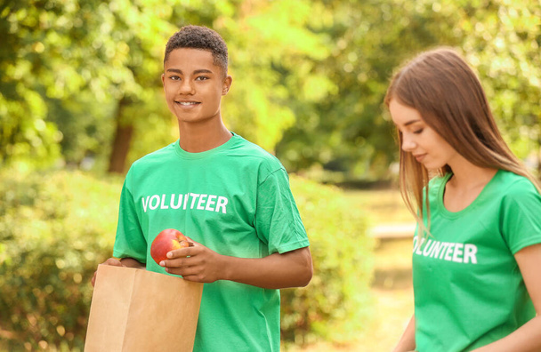 Jóvenes voluntarios con comida para pobres al aire libre
 - Foto, imagen